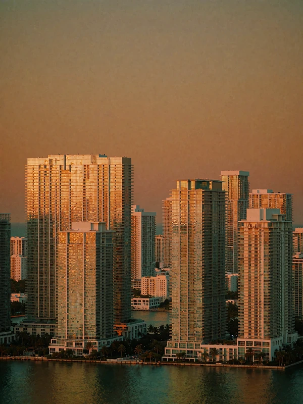 Illuminated Miami Brickell high-rise towers reflected in the bay after sunset