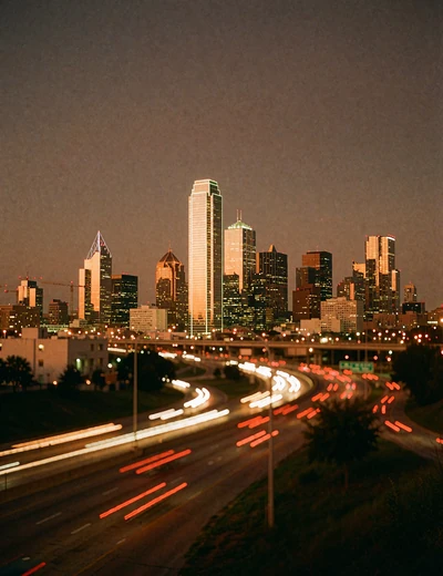 Dallas skyline towers glowing amber against a deep night sky